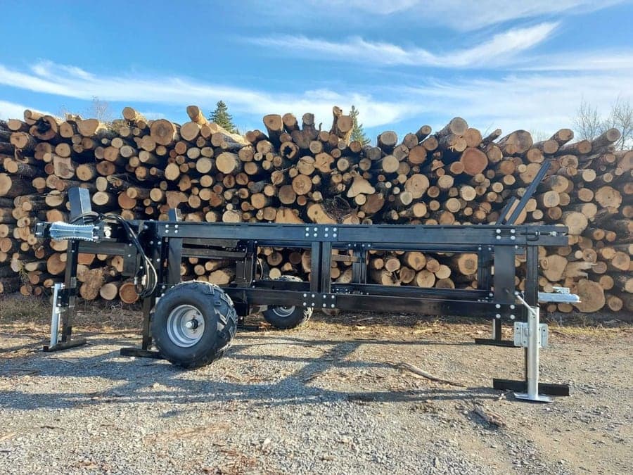 Combiné bois de chauffage CUTCRAFT devant un tas de bûches empilées