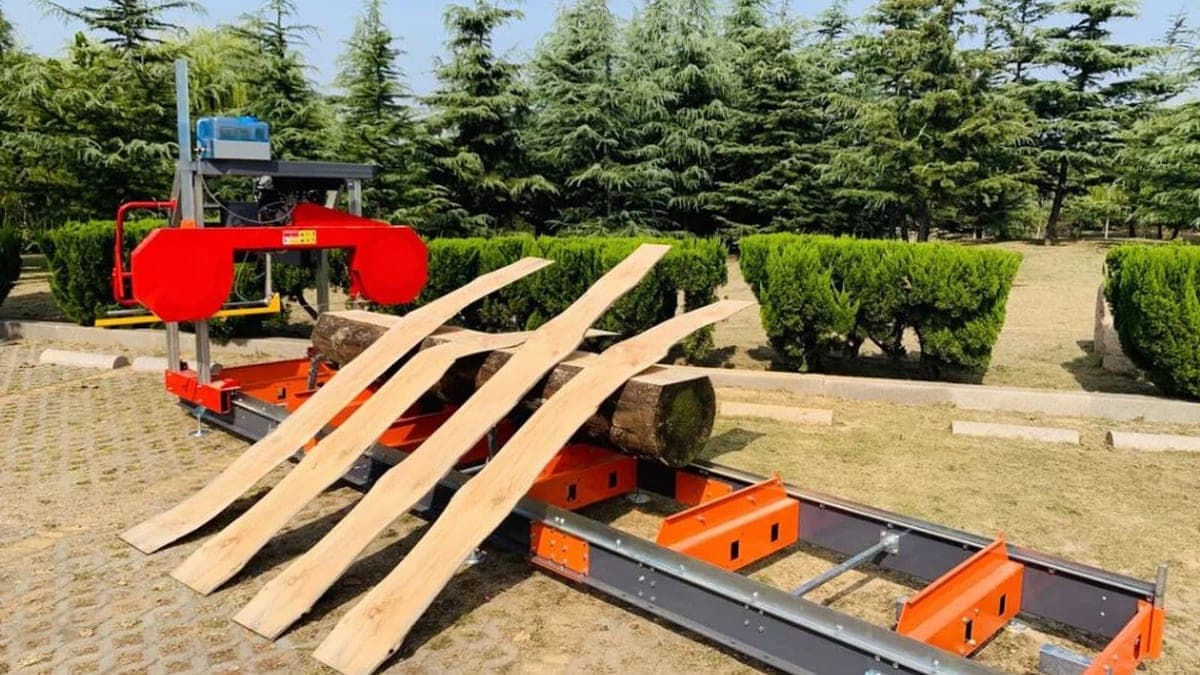 Scierie mobile installée en lisière de forêt pour le débitage de grumes sur chantier